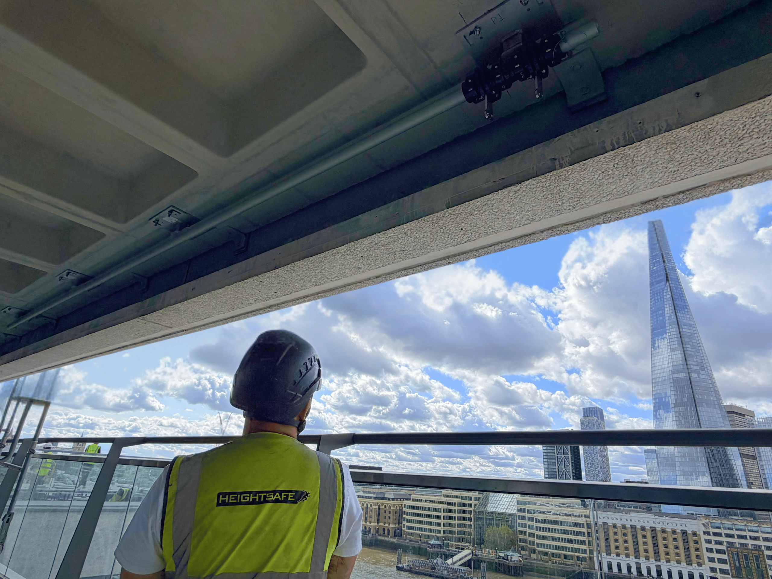 Heightsafe engineer stands in front of facade access monorail track installed by Heightsafe at Fresh Wharf London